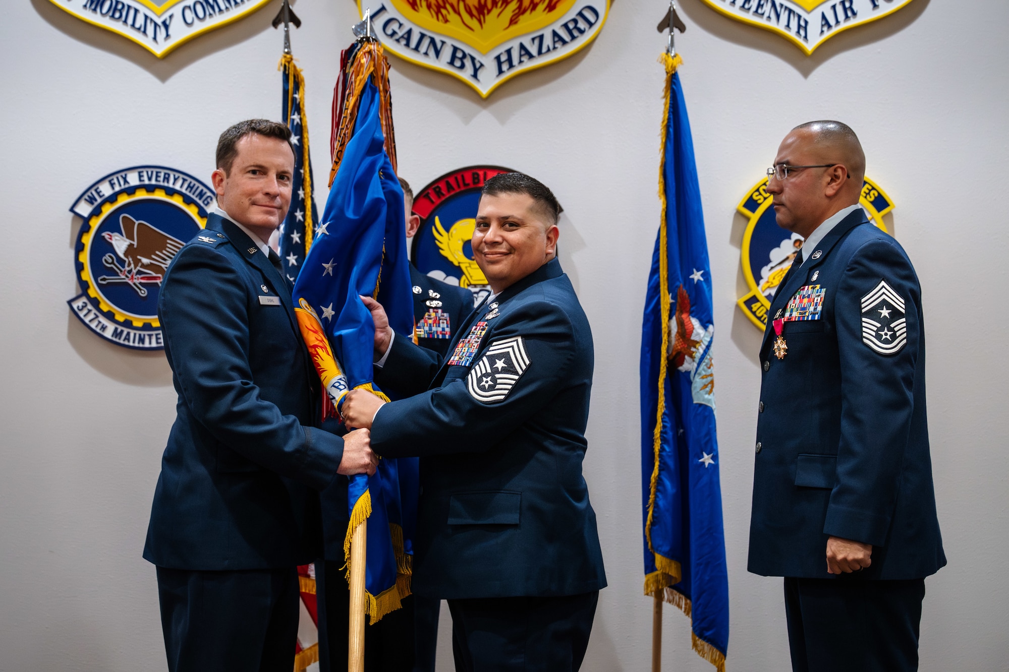U.S. Air Force Col. Justin Diehl, left, 317th Airlift Wing commander, passes the guidon to Chief Master Sgt. Brian Castillo, center, incoming 317th AW command chief, during a change of responsibilities ceremony at Dyess Air Force Base, Texas, June 12, 2026. The change of responsibility ceremony symbolizes the formal transfer of enlisted leadership through the passing of the unit's colors, representing the senior enlisted leader's responsibility for the discipline, readiness and welfare of the enlisted force. (U.S. Air Force photo by Senior Airman Jade M. Caldwell)
