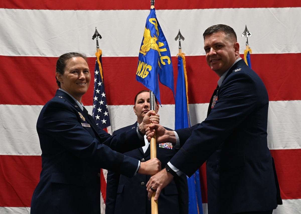 Two people hold flag on stage