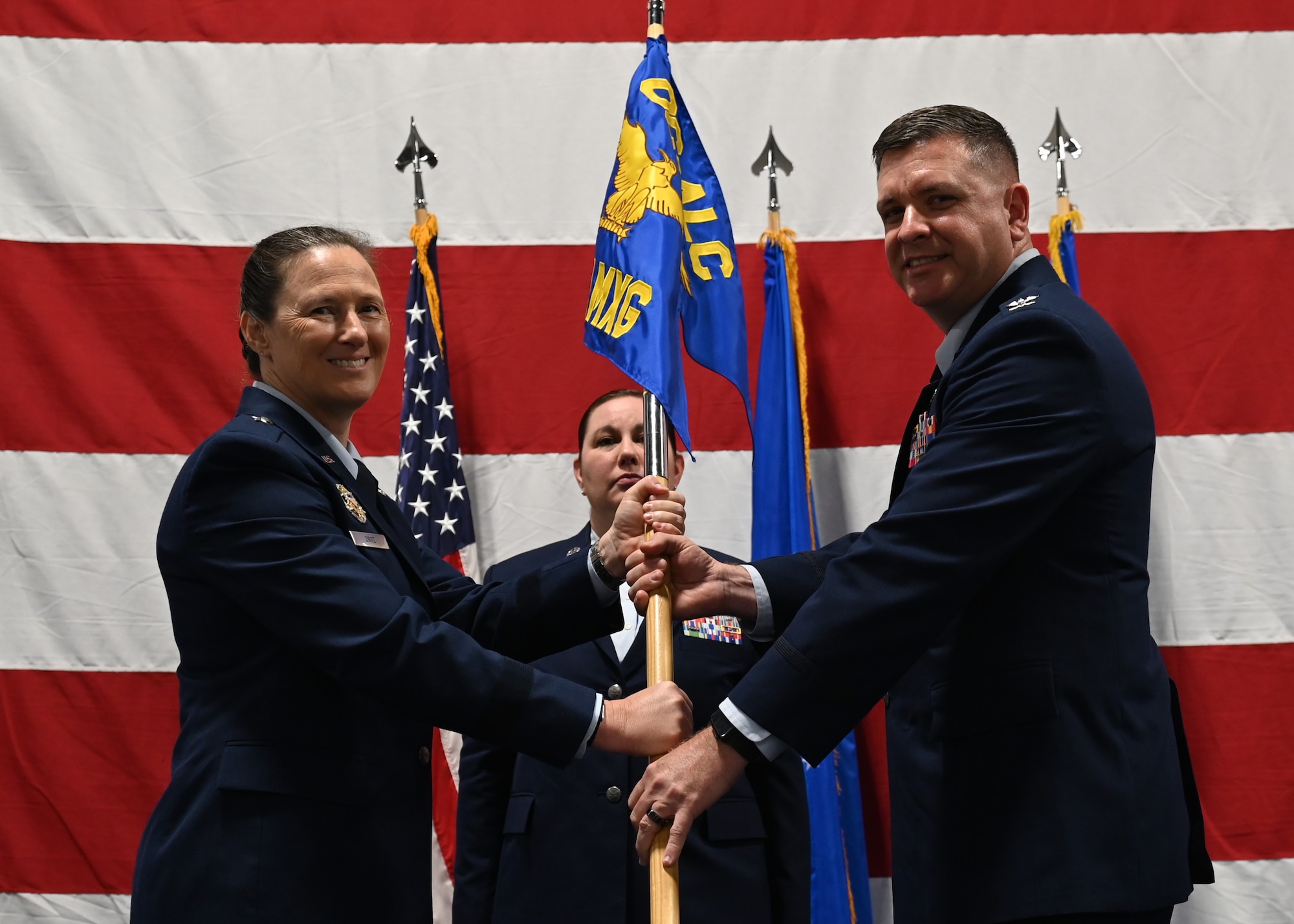 Two people hold flag on stage