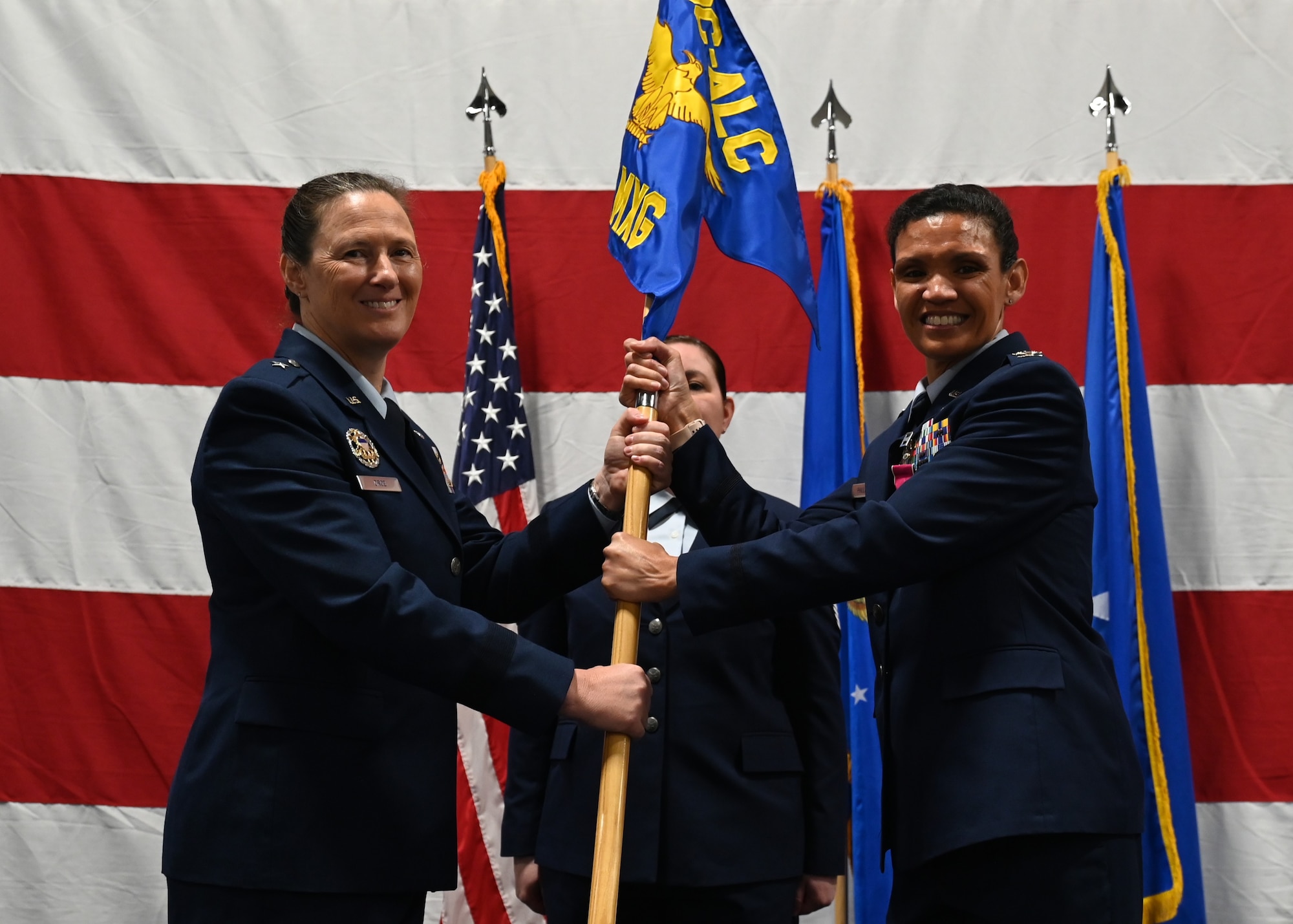 Two people smiling and holding a flag