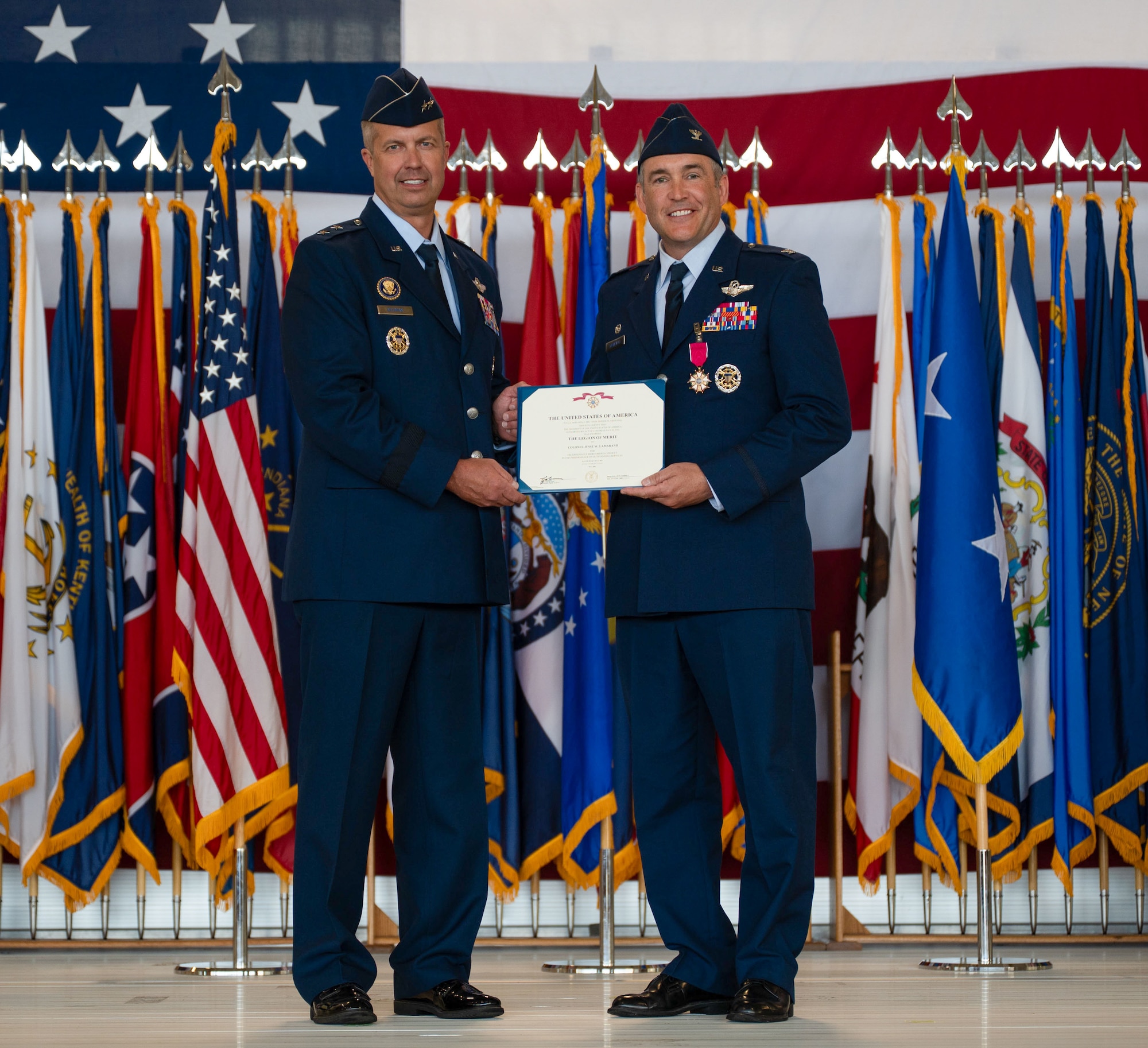 U.S. Air Force Col. Jesse Lamarand, 5th Bomb Wing (BW) outgoing commander, right, receives the Legion of Merit certificate from U.S. Air Force Maj. Gen. Ty Neuman, 8th Air Force and Joint-Global Strike Operations Center commander, left, during a change of command ceremony at Minot Air Force Base, North Dakota, July 9, 2026. As the 5th BW commander, Lamarand directed over 6,000 military and civilian personnel across the wing’s four groups, and was responsible for ensuring the combat readiness of the wing's B-52H Stratofortress fleet, providing long-range strike and strategic deterrence capabilities worldwide. (U.S. Air Force photo by Airman 1st Class Anthony Ramey)
