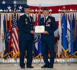 U.S. Air Force Col. Jesse Lamarand, 5th Bomb Wing (BW) outgoing commander, right, receives the Legion of Merit certificate from U.S. Air Force Maj. Gen. Ty Neuman, 8th Air Force and Joint-Global Strike Operations Center commander, left, during a change of command ceremony at Minot Air Force Base, North Dakota, July 9, 2026. As the 5th BW commander, Lamarand directed over 6,000 military and civilian personnel across the wing’s four groups, and was responsible for ensuring the combat readiness of the wing's B-52H Stratofortress fleet, providing long-range strike and strategic deterrence capabilities worldwide. (U.S. Air Force photo by Airman 1st Class Anthony Ramey)