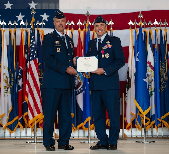 U.S. Air Force Col. Jesse Lamarand, 5th Bomb Wing (BW) outgoing commander, right, receives the Legion of Merit certificate from U.S. Air Force Maj. Gen. Ty Neuman, 8th Air Force and Joint-Global Strike Operations Center commander, left, during a change of command ceremony at Minot Air Force Base, North Dakota, July 9, 2026. As the 5th BW commander, Lamarand directed over 6,000 military and civilian personnel across the wing’s four groups, and was responsible for ensuring the combat readiness of the wing's B-52H Stratofortress fleet, providing long-range strike and strategic deterrence capabilities worldwide. (U.S. Air Force photo by Airman 1st Class Anthony Ramey)
