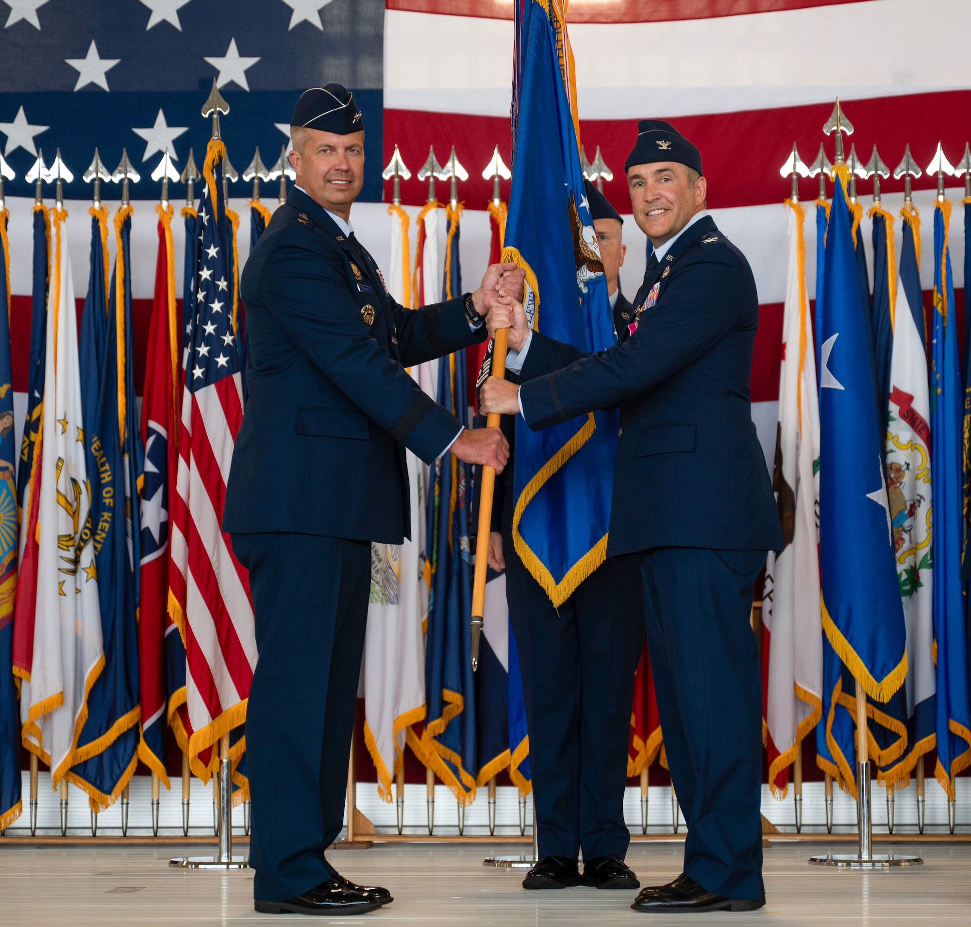 U.S. Air Force Col. Jesse Lamarand, 5th Bomb Wing (BW) outgoing commander, right, relinquishes the guidon to U.S. Air Force Maj. Gen. Ty Neuman, 8th Air Force and Joint-Global Strike Operations Center commander, left, during a change of command ceremony at Minot Air Force Base, North Dakota, July 9, 2026. As the 5th BW commander, Lamarand directed over 6,000 military and civilian personnel across the wing’s four groups, and was responsible for ensuring the combat readiness of the wing's B-52H Stratofortress fleet, providing long-range strike and strategic deterrence capabilities worldwide.(U.S. Air Force photo by Airman 1st class Anthony Ramey)