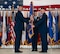 U.S. Air Force Maj. Gen. Ty Neuman, 8th Air Force and Joint-Global Strike Operations Center commander, left, relinquishes the guidon to U.S. Air Force Col. John Burrell, 5th Bomb Wing (BW) incoming commander, right, during a change of command ceremony at Minot Air Force Base, North Dakota, July 9, 2026. As the incoming commander, Burrell is responsible for leading the 5th BW’s B-52H Stratofortress operations and ensuring the wing remains ready to provide global strike capabilities in support of Air Force Global Strike Command’s strategic deterrence mission. (U.S. Air Force photo by Airman 1st class Anthony Ramey)