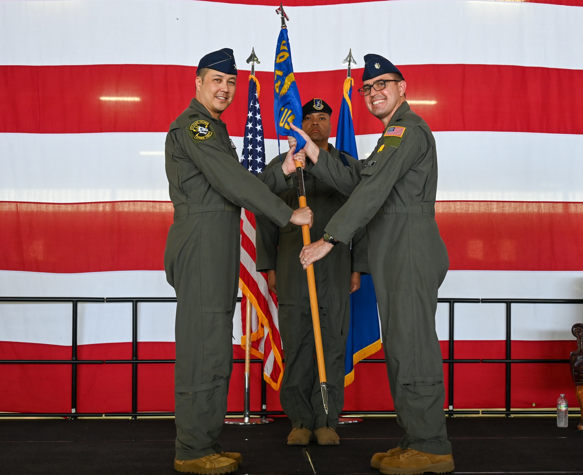 From the left, U.S. Air Force Lt. Col. Aaron Borszich, 47th Student Squadron (STUS) outgoing commander, presents the 47th STUS guidon to Col. Richard Greig, 47th Operations Group commander, during the 47th STUS change of command ceremony at Laughlin Air Force Base, Texas, July 10, 2026. Change of command ceremonies represent a formal transfer of authority and responsibility of a unit from one commanding officer to another. (U.S. Air Force photo by Airman 1st Class Kylie Rabb)