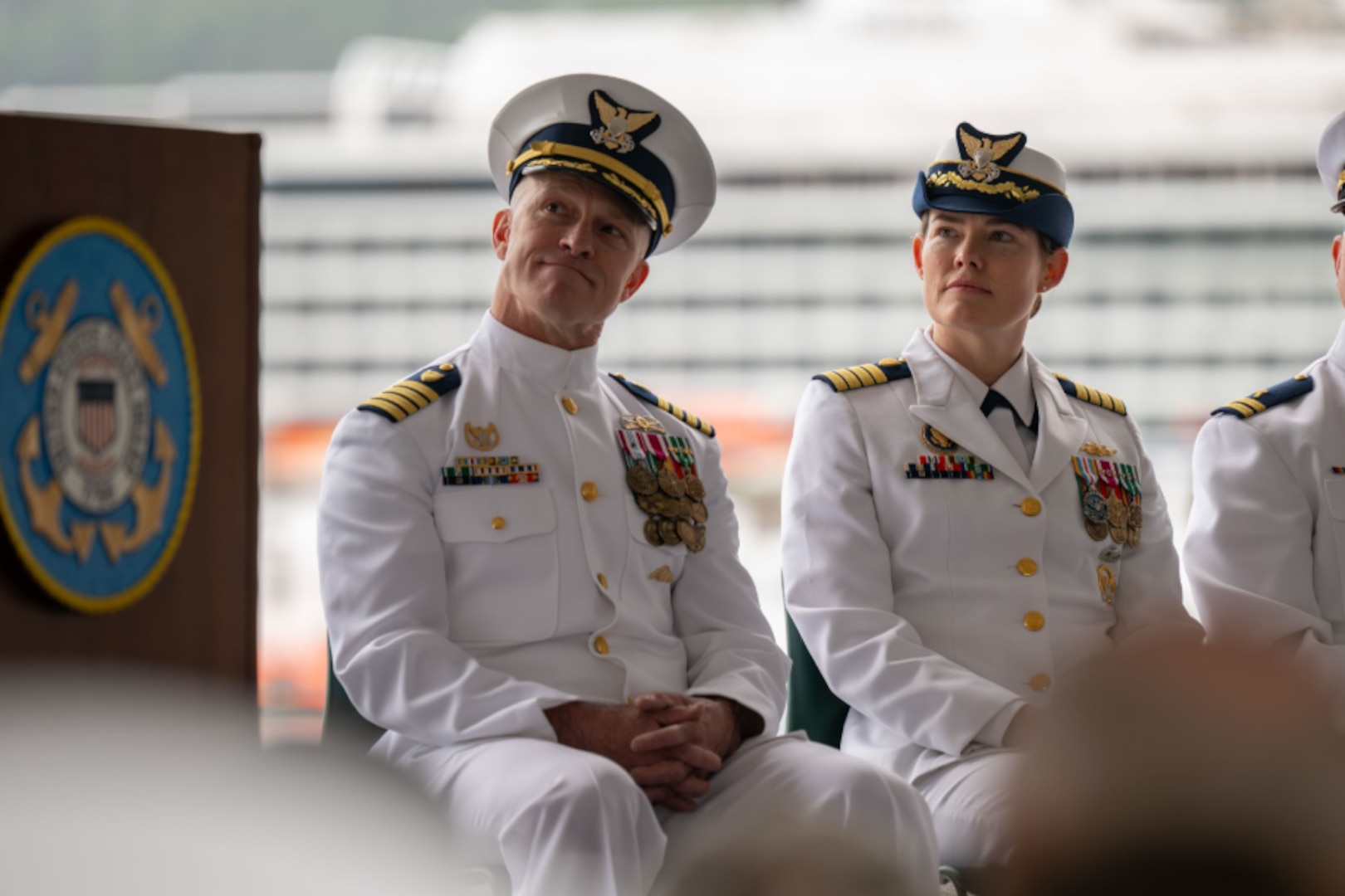 Capt. Stanley Fields, the outgoing Coast Guard Sector Southeast Alaska commander, left, and Capt. Ginny Nadolny, the incoming sector commander, right, sit during a change of command ceremony at Coast Guard Station Juneau, Alaska, July 10, 2026.