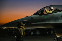 A crew chief marshals a U.S. Air Force F-16 Fighting Falcon before taxiing at an undisclosed location within the U.S. Central Command area of responsibility, June 16, 2026. The sortie supported ongoing regional operations and maintained the aircraft’s readiness to provide airpower across the theater. (U.S. Air Force photo by Staff Sgt. Justin W. Moore)