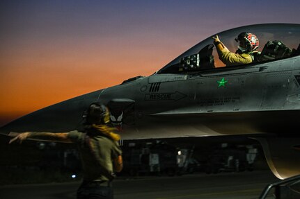 A crew chief marshals a U.S. Air Force F-16 Fighting Falcon before taxiing at an undisclosed location within the U.S. Central Command area of responsibility, June 16, 2026. The sortie supported ongoing regional operations and maintained the aircraft’s readiness to provide airpower across the theater. (U.S. Air Force photo by Staff Sgt. Justin W. Moore)