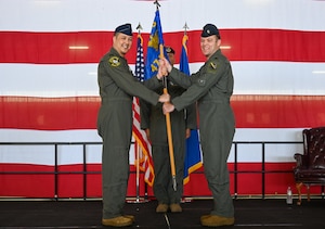 From the left, U.S. Air Force Lt. Col. Dane Coppini, 47th Student Squadron (STUS) incoming commander, is presenteds the 47th STUS guidon from Col. Richard Greig, 47th Operations Group commander, during the 47th STUS change of command ceremony at Laughlin Air Force Base, Texas, July 10, 2026. Change of command ceremonies represent a formal transfer of authority and responsibility of a unit from one commanding officer to another. (U.S. Air Force photo by Airman 1st Class Kylie Rabb)