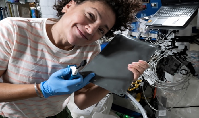NASA astronaut Jessica Meir poses with the Airion Advanced Inflight Relief Universal System (AIRUS) aboard the International Space Station on an unknown date. The AIRUS bladder relief system, originally developed through the AFWERX Sky High Relief Challenge to improve in-flight bladder relief for military aviators, launched aboard NASA's SpaceX Crew-12 mission to the International Space Station on Feb. 13, 2026, as a technology demonstration. The effort highlights how Air Force-driven innovation transitioned from addressing an operational need for Airmen to supporting long-duration human spaceflight. (Courtesy photo/NASA)