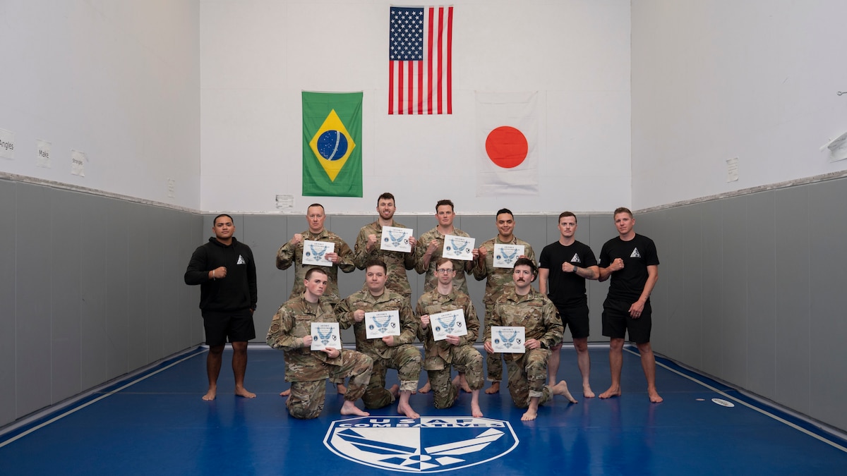 Airmen pose for a photo with certificates in hand.