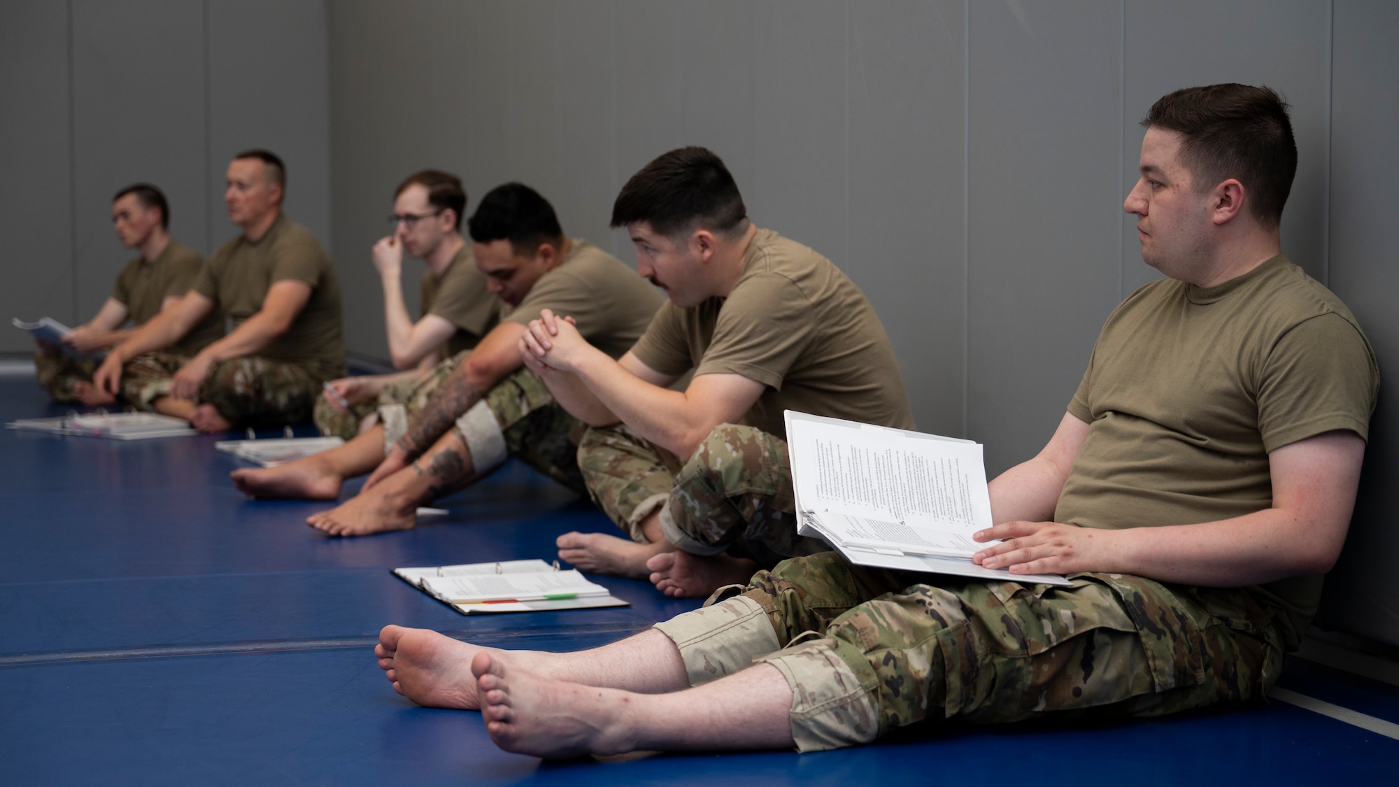 Airmen sit and learn about combatives.