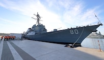 NAVAL STATION TARANTO, Italy (Sept. 23, 2025) U.S. Navy Sailors, assigned to Navy Cargo Handling Battalion One (NCHB-1), render a hand salute during morning colors in front of the Arleigh Burke-class guided-missile destroyer USS Roosevelt (DDG 80) at Naval Station Taranto, Italy, Sept. 23, 2025.