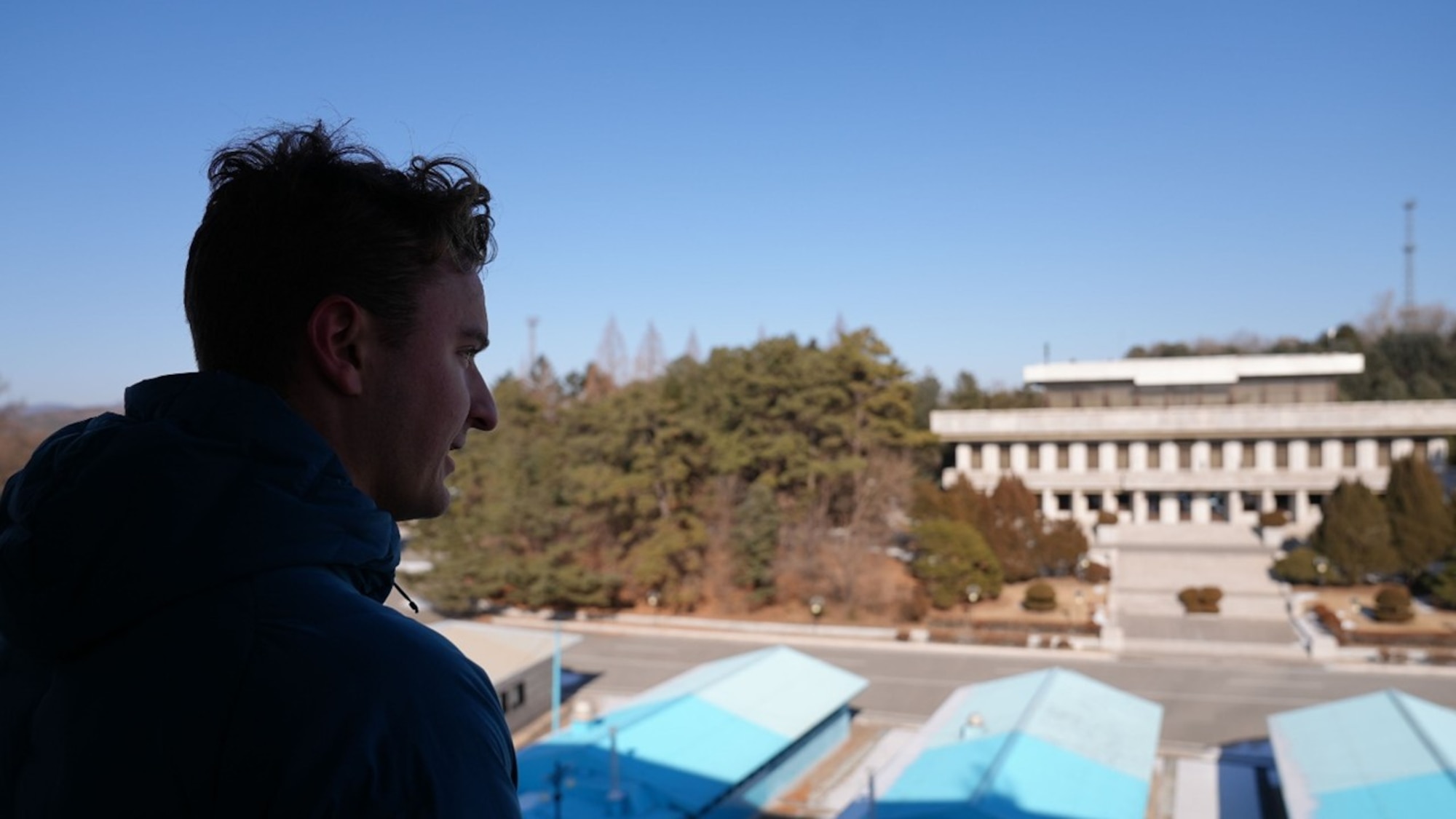 U.S. Air Force 2nd Lt. Zachary Derwin, Air Force Research Laboratory electrical and computer engineer, looks towards the Joint Security Area inside the Demilitarized Zone in Panmunjeom, Republic of Korea, Jan. 20, 2026. AFRL team members visited the DMZ as part of an initiative to connect researchers with operational realities. This visit highlighted the critical role the science and technology community plays in American deterrence, motivating the AFRL workforce to develop the capabilities needed to ensure the combined force remains ready to defend the Republic of Korea. (U.S. Air Force photo by Allegra Czerwinski)