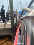 A Coast Guard Station Islamorada boat crew transfers a rescued diver to emergency medical services at Garden Cove Marina after the boat crew rescued the overdue diver, 5 miles east of John Pennekamp State Park, July, 11, 2026. Coast Guard Sector Key West watchstanders issued an urgent marine broadcast approximately 15 minutes after the diver was scheduled to surface. (U.S. Coast Guard photo)