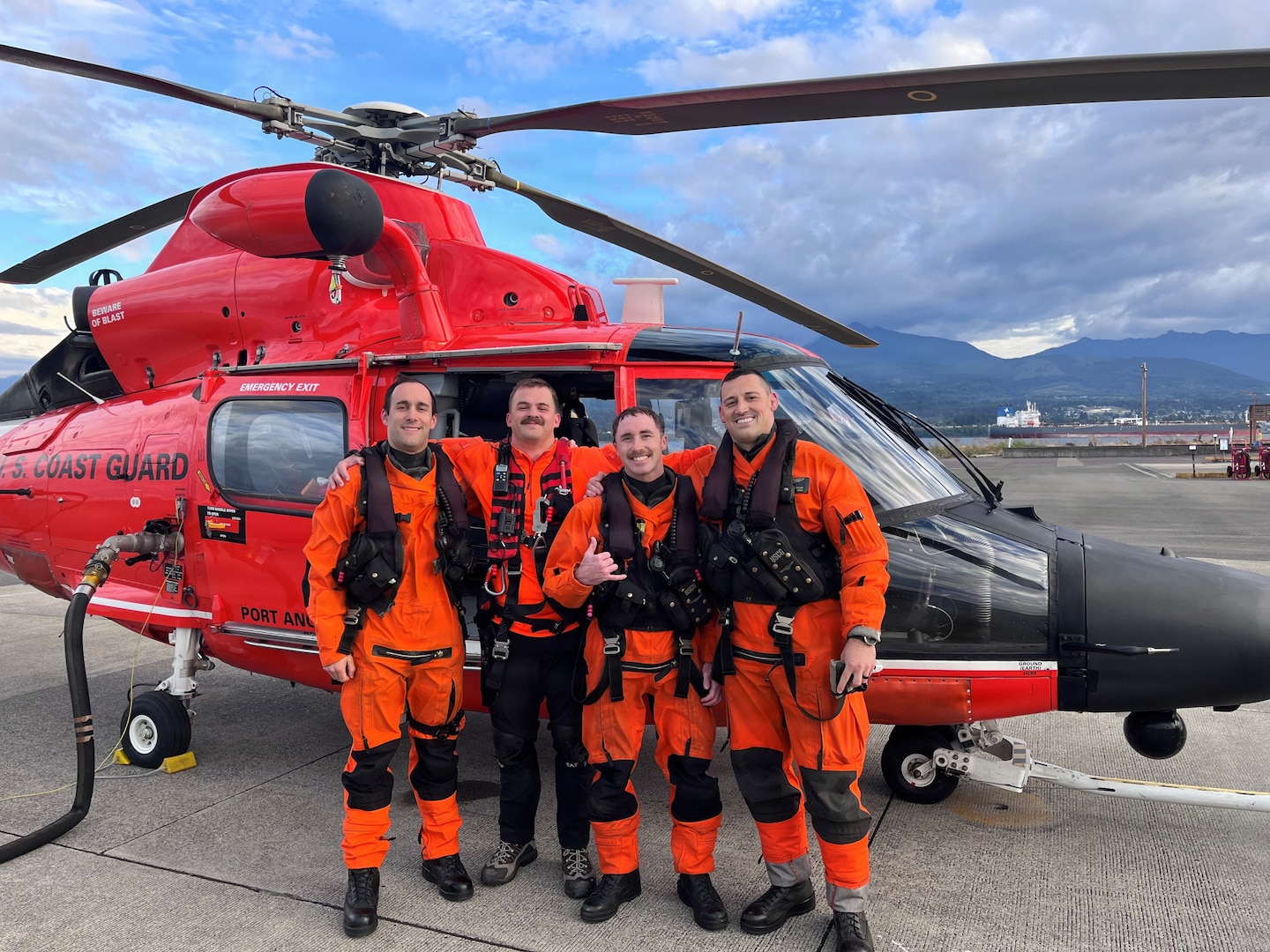 A U.S. Coast Guard MH-65 Dolphin helicopter crew from Air Station Port Angeles poses for a photo after completing a medevac from Shi Shi Beach