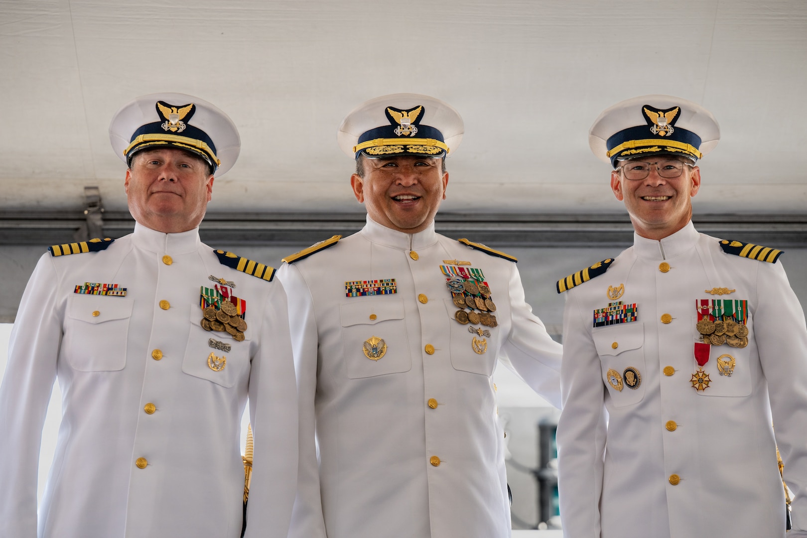 U.S. Coast Guard Capt. Michael Hunt (left), incoming commanding officer of Coast Guard Sector Puget Sound, rRear Adm. Arex Avanni (center), commander of the Coast Guard Northwest District, and Capt. Mark McDonnell (right), outgoing commanding officer of the sector, stand for a photo during a change of command ceremony in Seattle, Washington, July 10, 2026