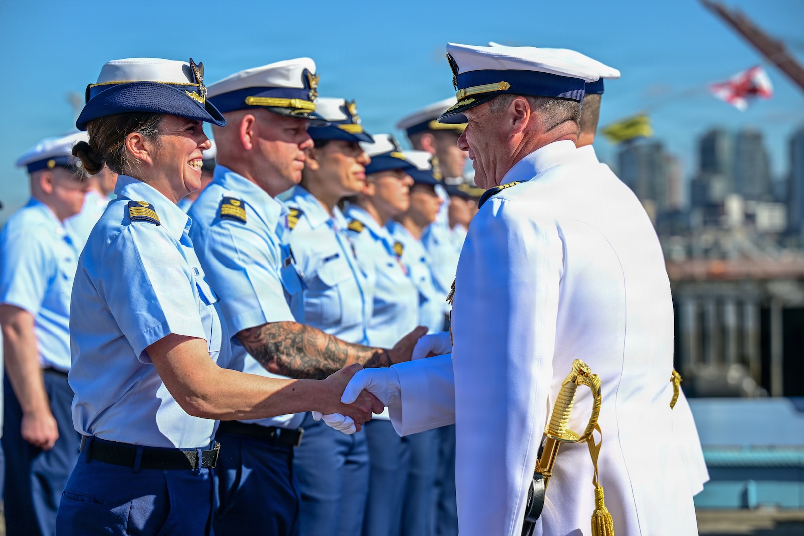 U.S. Coast Guard Captains Mark A. McDonnell and Michael J. Hunt shake hands with Sector Puget Sound members during a change of command ceremony in Seattle, Washington, July 10, 2026