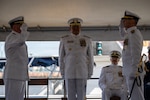U.S. Coast Guard Capt. Michael Hunt (left), incoming commanding officer of Coast Guard Sector Puget Sound, renders a salute to Capt. Mark McDonnell (right), outgoing commanding officer of the sector, while Rear Adm. Arex Avanni (center), commander of the Coast Guard Northwest District, officiates the pass down during the Coast Guard Sector Puget Sound change-of-command ceremony in Seattle, Washington, July 10, 2026