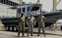 U.S. Army Command Sgt. Maj. Scott McKennon, Staff Sgt. Nathan Fioramonti and Sgt. Nigeria Myers with the District of Columbia National Guard, assigned to Joint Task Force District of Columbia, in support of the DC Safe and Beautiful mission, pose in front of the newly transferred 260th Special Purpose Brigade boat in Williamsburg, Va., June 26, 2026. About 4,500 National Guard members are supporting the mission, providing critical assistance to the Metropolitan Police Department to help ensure the safety of residents, commuters, and visitors throughout the District.