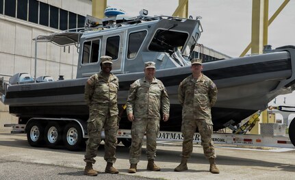 U.S. Army Command Sgt. Maj. Scott McKennon, Staff Sgt. Nathan Fioramonti and Sgt. Nigeria Myers with the District of Columbia National Guard, assigned to Joint Task Force District of Columbia, in support of the DC Safe and Beautiful mission, pose in front of the newly transferred 260th Special Purpose Brigade boat in Williamsburg, Va., June 26, 2026. About 4,500 National Guard members are supporting the mission, providing critical assistance to the Metropolitan Police Department to help ensure the safety of residents, commuters, and visitors throughout the District.