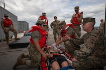 U.S. Navy Cmdr. Michael Monson, right, a group surgeon with 3rd Marine Logistics Group, advises Army Soldiers with 331st Transportation Company Causeway, 11th Transportation Battalion, 7th Transportation Brigade (Expeditionary), on medical care procedures as a part of casualty evacuation training during Combined Joint Logistics Over-the-Shore training on Dogu Beach, Pohang, South Korea, July 9, 2026. The combined training between the U.S. Navy, Army, and Coast Guard personnel rehearsed expeditionary medical procedures and strengthened cross-service experience for providing care in austere and contested environments. CJLOTS 26 is a combined exercise designed to integrate U.S. and Republic of Korea lighterage and ship-to-shore connector capabilities, improve combined readiness, strengthen the Republic of Korea-U.S. alliance, and expand combined maritime sustainment capacity during logistics operations. (U.S. Marine Corps photo by Lance Cpl. Marcus Henson)