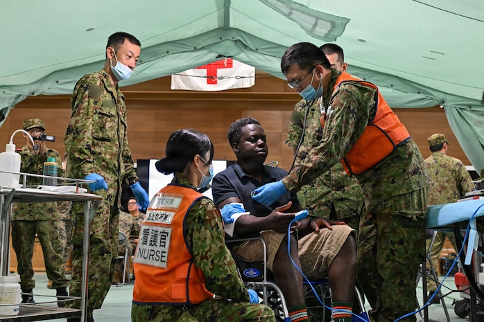 Japan Ground Self-Defense Force service members perform a medical assessment on a simulated casualty during a humanitarian assistance and disaster relief scenario as part of Resolute Dragon 26 at Camp Miyako, Okinawa, Japan on June 26, 2026. Resolute Dragon is an annual bilateral exercise in Japan that strengthens the command, control, and multi-domain maneuver capabilities of U.S. Marines in III Marine Expeditionary Forces and Japan Self-Defense Forces personnel, with a focus on controlling and defending key maritime terrain. (U.S. Marine Corps photo by Lance Cpl. Nathan Saucier)