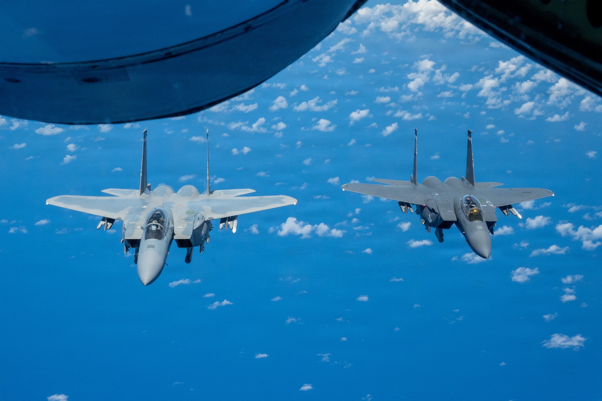 view of two fighter aircraft in formation from a refueling aircrafts boom pod window