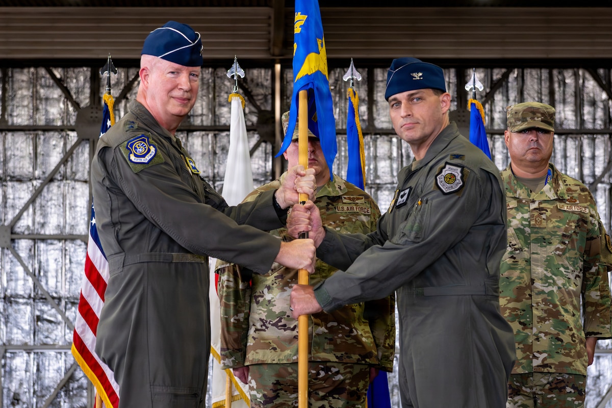 U.S. Air Force Lt. Gen. Joel Carey, left, 5th Air Force commander, passes the guidon to Col. Oliver Lause, incoming 35th FW commander, during a change of command ceremony.