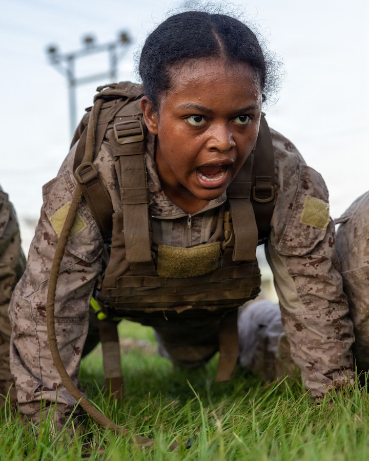 U.S. Marine Corps Cpl. Trayana Robinson, an Intelligence Analyst with 3rd Marine Division, leads a group of Marines in conducting push-ups during a Marine Corps Martial Arts Program culminating event on Camp Courtney, Okinawa, Japan, June 25, 2026. MCMAP enhances unit readiness and lethality while fostering leadership, mental discipline, and character development. Robinson is a native of Nevada. (U.S. Marine Corps photo by Lance Cpl. Kylee DiSanto)
