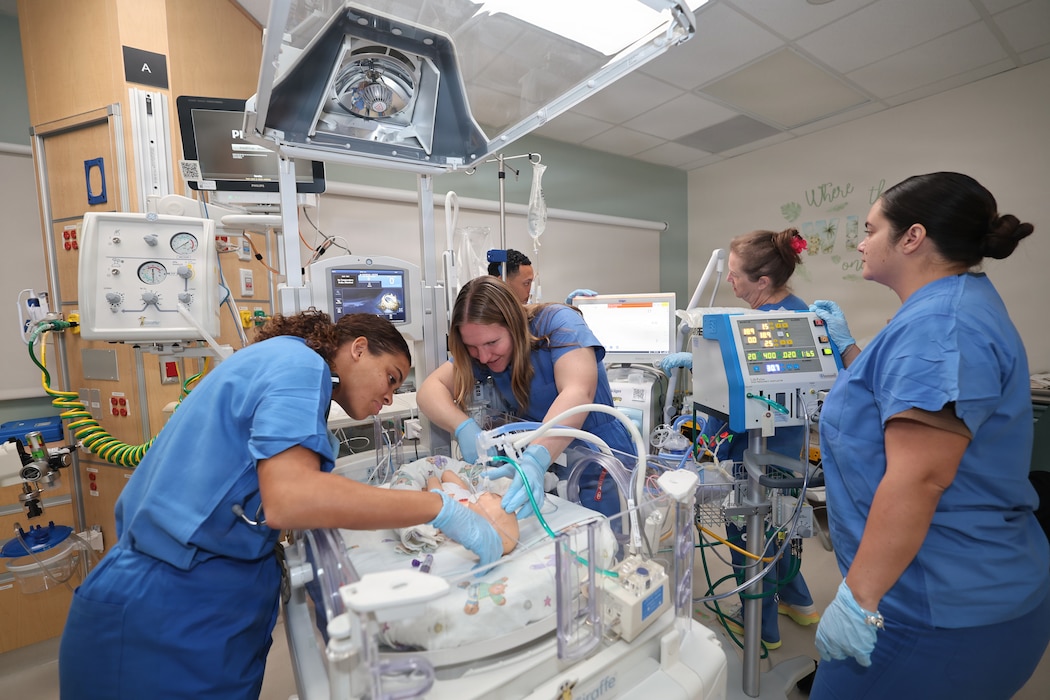 A team of respiratory therapists and a nurse at U.S. Naval Hospital Guam practice setting up an advanced dual-ventilator system on a simulated infant patient. Together, these machines deliver rapid, tiny breaths that safely oxygenate a premature baby while preventing damage to their delicate lungs. USNH Guam is expanding pediatric capabilities to improve care, increase local medical capacity, and strengthen operational readiness across the Indo-Pacific. By increasing treatment capability on island, USNH Guam ensures service members and their families receive the care they need, where they serve.