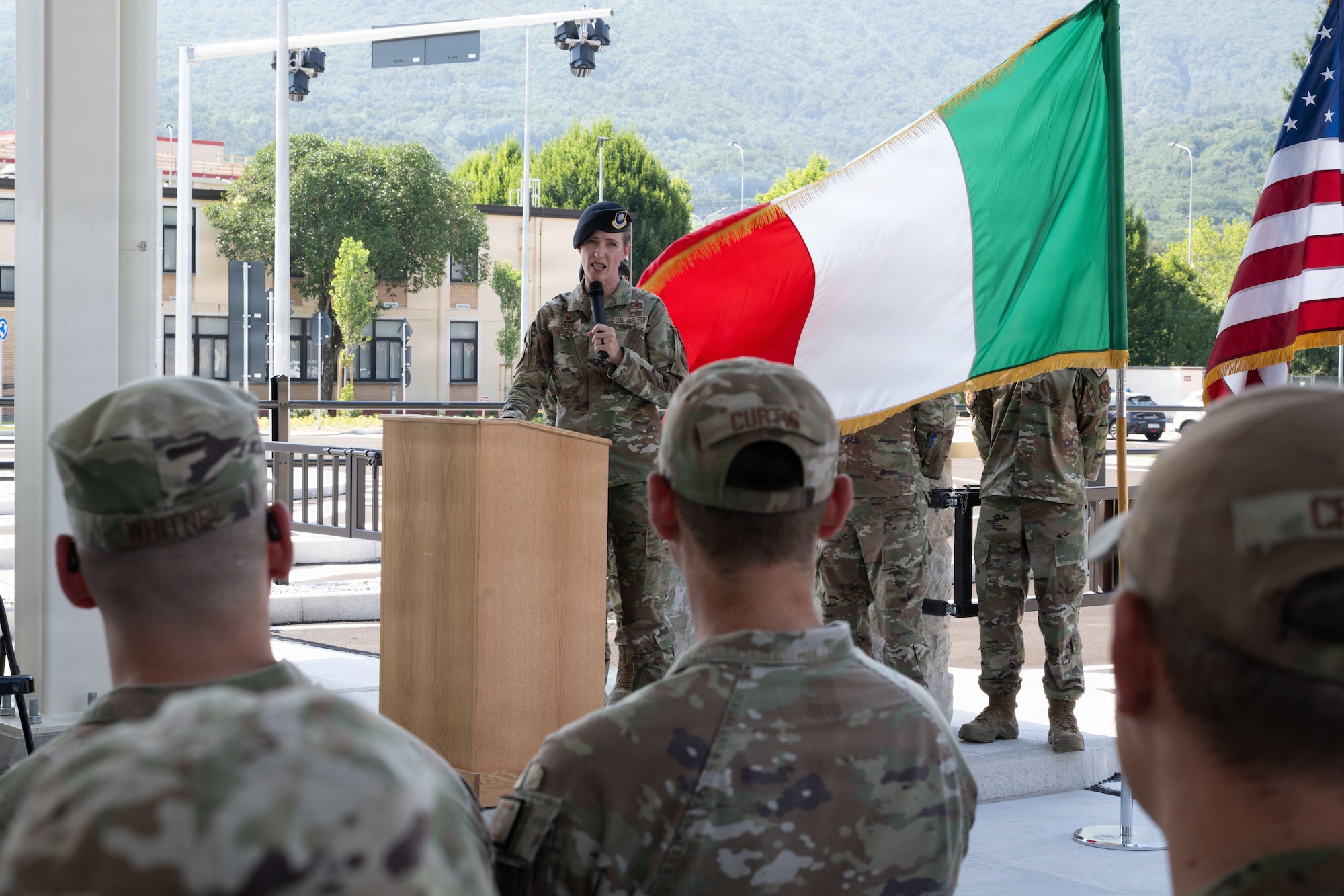 The commander of the 31st Security Forces Squadron stands at a podium and speaks to other military members in the crowd.