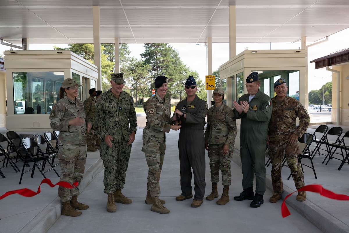 A group of people in military uniforms cut the ribbon at the gate opening on Area 1.