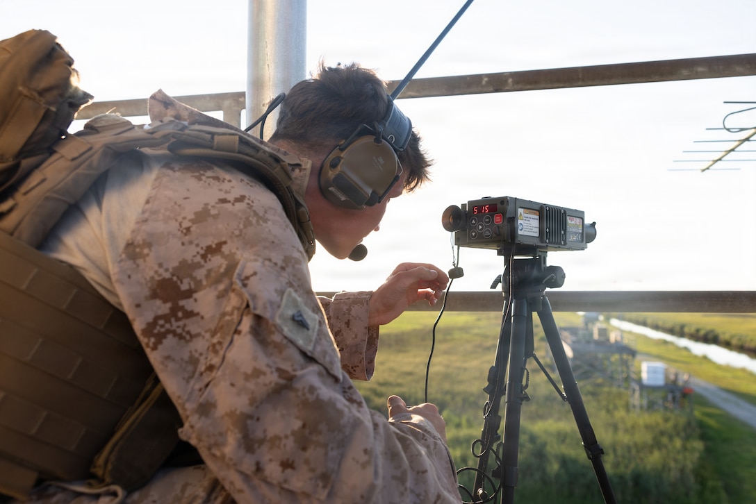 U.S. Marine Corps Cpl. Andrew Wilson, a fire support Marine with 2nd Air Naval Gunfire Liaison Company, II Marine Expeditionary Force Information Group, coordinates close-air support with an AH-1Z Viper helicopter during exercise Mjolnir Strike at Bombing Target 11 on Piney Island, North Carolina, July 1, 2026. Marine Corps Air Station Cherry Point’s outlying fields and ranges, such as BT-11, are frequently used locations for quality training by the Department of War and U.S. allies. Mjolnir Strike is joint terminal attack controller training that is instrumental in the success of the Marine Air-Ground Task Force by providing realistic training opportunities. (U.S. Marine Corps photo by Lance Cpl. Dylan Swertfeger)