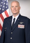 photo of US Airman standing in front of a US flag
