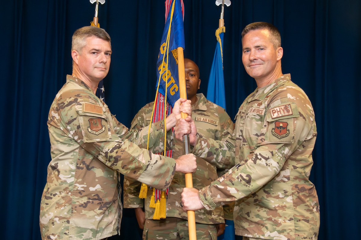 Two servicemembers exchange a guidon