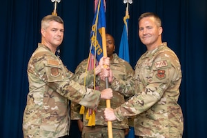 Two servicemembers exchange a guidon