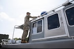 U.S. Army National Guard Spc. Luke Martinez Acuna, assigned to Joint Task Force- District of Columbia in support of the DC Safe and Beautiful mission, conducts Preventive Maintenance Checks and Services on a boat to ensure its mission capability on Joint Base Anacostia-Bolling in Washington, D.C., July 8, 2026. About 5,000 National Guard members are supporting the mission, providing critical assistance to the Metropolitan Police Department to help ensure the safety of residents, commuters and visitors throughout the District. Photo by Staff Sgt. Tianna Wilson.