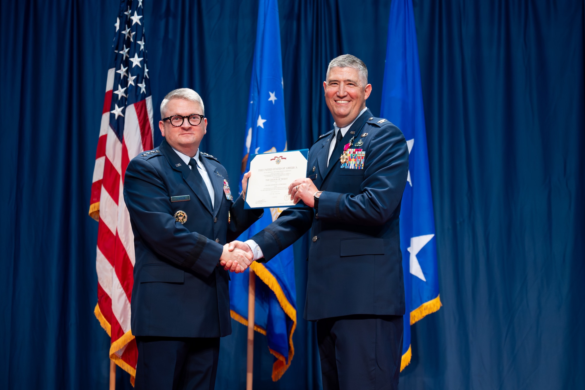 Lt. Gen. Max Pearson, Deputy Chief of Staff for Intelligence, presents the Legion of Merit to Col. Kenneth Stremmel, outgoing National Air and Space Intelligence Center commander, during the NASIC change of command ceremony at the National Museum of the United States Air Force, Wright-Patterson Air Force Base, Ohio, July 10, 2026. The award recognized Stremmel for his meritorious service and leadership while commanding the Department of the Air Force’s primary source for foreign air and space intelligence. (U.S. Air Force photo by Staff Sgt. Kristof J. Rixmann)