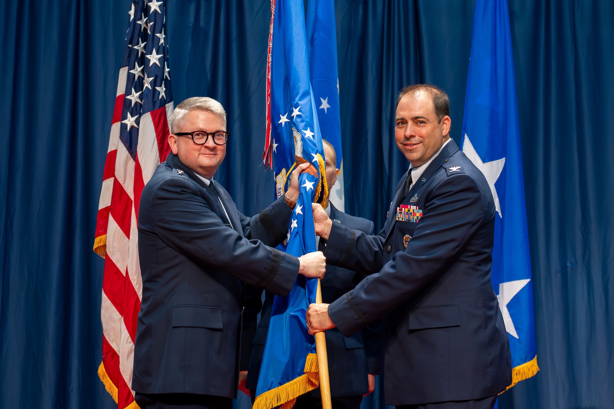 Col. Tyson Wetzel, incoming National Air and Space Intelligence Center commander, receives the NASIC guidon from Lt. Gen. Max Pearson, Deputy Chief of Staff of Intelligence, during a change of command ceremony at the National Museum of the United States Air Force, Wright-Patterson Air Force Base, Ohio, July 10, 2026. By accepting the guidon, Wetzel takes charge of the Center, which encompasses four groups, five directorates, and 17 squadrons. (U.S. Air Force photo by Staff Sgt. Kristof J. Rixmann)