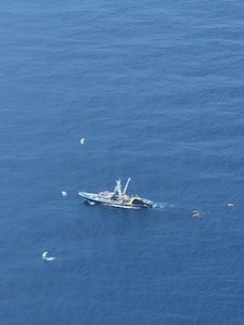 Pararescuemen from the 131st Rescue Squadron prepare to board the Mexican fishing vessel Franz, after jumping from the 129th Rescue Wing's HC-130J Combat King II, on July 7, 2026.