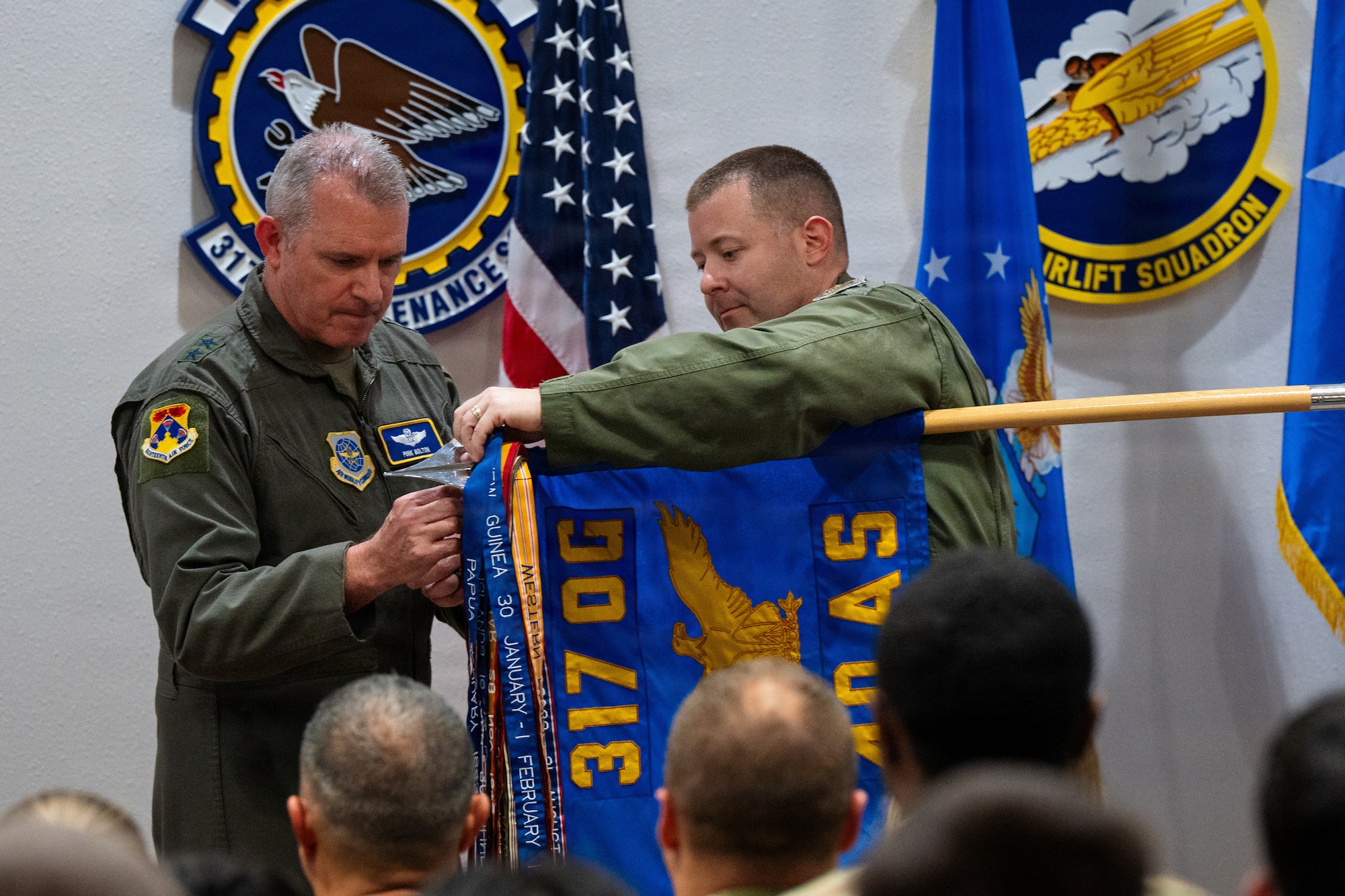 U.S. Air Force Maj. Gen. Charles Bolton, left, Eighteenth Air Force commander, pins the Gallant Unit Citation to the 40th Airlift Squadron guidon alongside Lt. Col. Brendan Wier, 40th AS commander, at Dyess Air Force Base, Texas, July 7, 2026. The award is presented to Air Force active duty, Reserve and Air National Guard units for extraordinary heroism in action against an armed enemy of the United States while engaged in military operations involving conflict with an opposing foreign force on or after Sept. 11, 2001. (U.S. Air Force photo by Senior Airman Jade M. Caldwell)