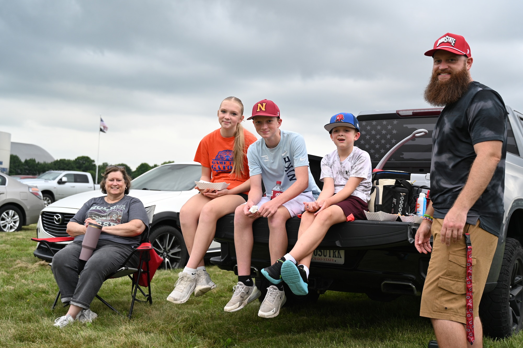 Family sitting on their vehicle's tailgate and lawn chairs waiting for the show to begin.