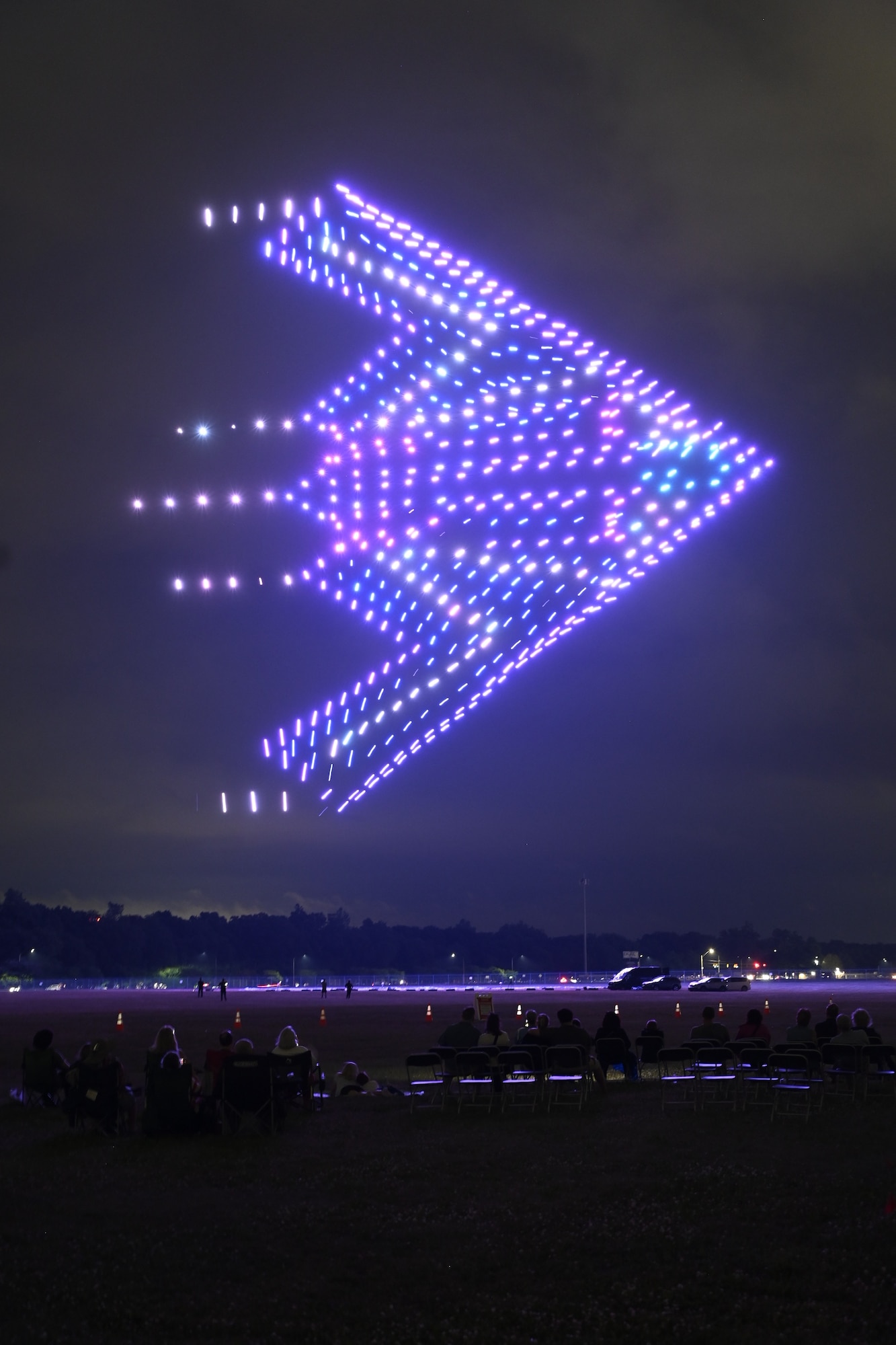 A formation of illuminated drones creates a B-2 bomber in the night sky during the Lights Over Dayton drone show at the National Museum of the U.S. Air Force.