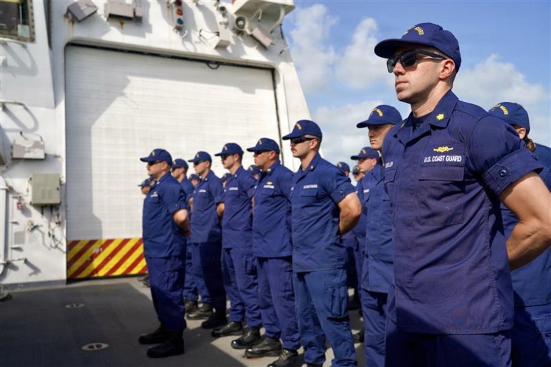 U.S. Coast Guard crewmembers aboard Coast Guard Cutter James, stand at parade rest during a change of command ceremony in Key West, Florida July 9, 2026. The James is one of four 418-foot Legend-class national security cutters homeported in Charleston, South Carolina, under U.S. Coast Guard Atlantic Area Command. (U.S. Coast Guard photo)