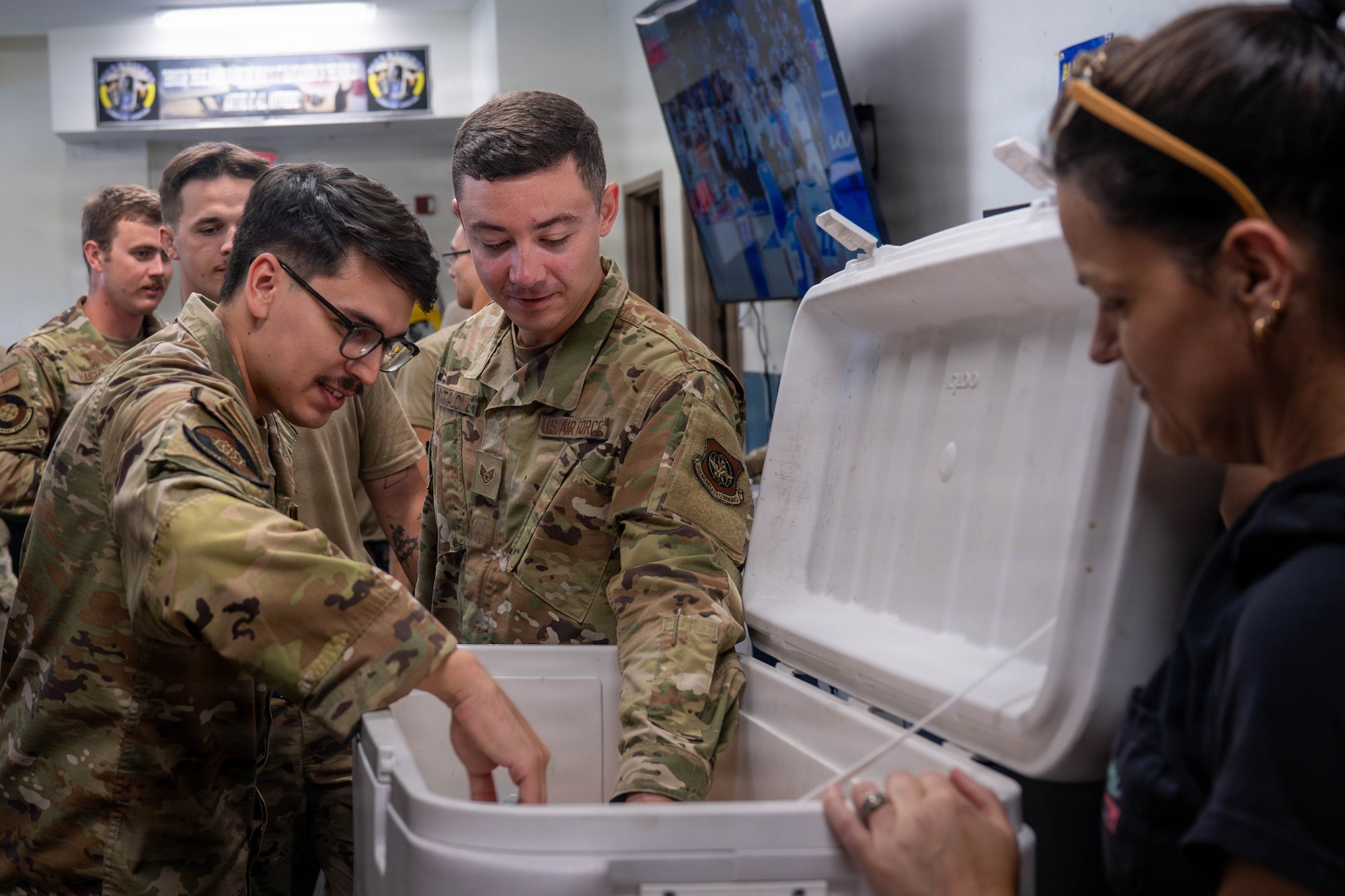 A photo of several Airmen getting refreshments from a cooler.