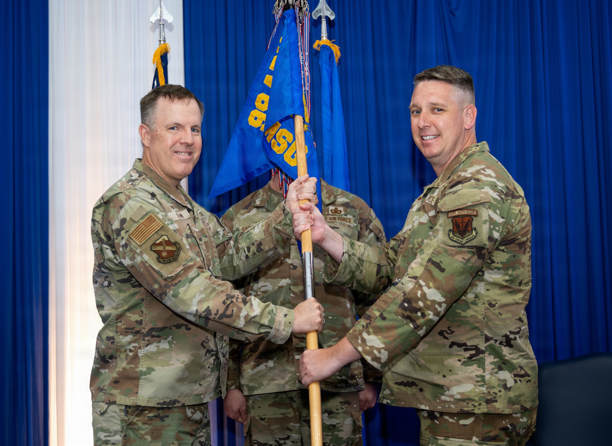 Two people holding guidon