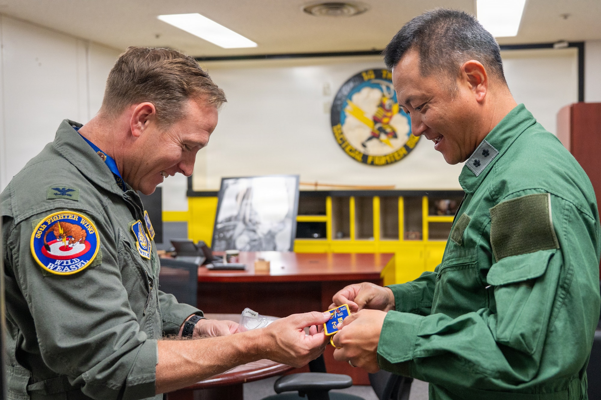 U.S. Air Force Col. Paul “Voodoo” Davidson, 35th Fighter Wing commander, left, presents a patch to Japan Air Self-Defense Force Maj. Gen. Teru “Beacon” Tomikawa, 3rd Air Wing commander, during a familiarization flight visit at Misawa Air Base, Japan, June 30, 2026