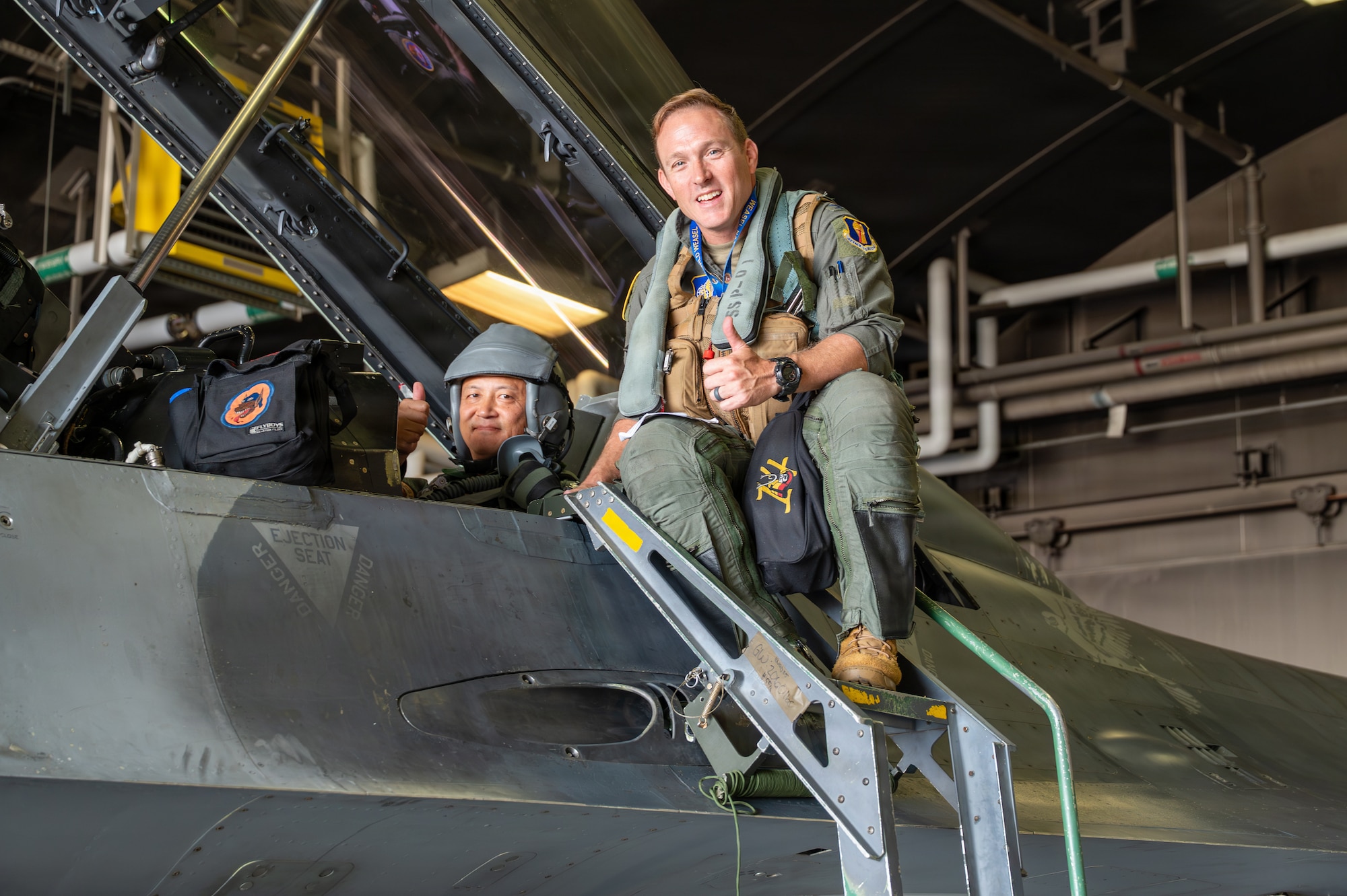 Japan Air Self-Defense Force (JASDF) Maj. Gen. Teru “Beacon” Tomikawa, 3rd Air Wing commander, left, prepares for a familiarization flight with U.S. Air Force Col. Paul “Voodoo” Davidson, 35th Fighter Wing commander, aboard an F-16 Fighting Falcon at Misawa Air Base, Japan, June 30, 2026